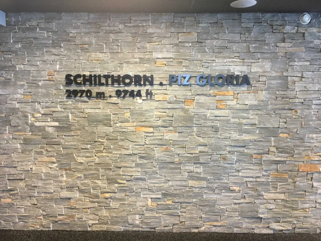 Steinwand mit Schriftzug: Schilthorn – Piz Gloria, 2970 m, 9744 ft.